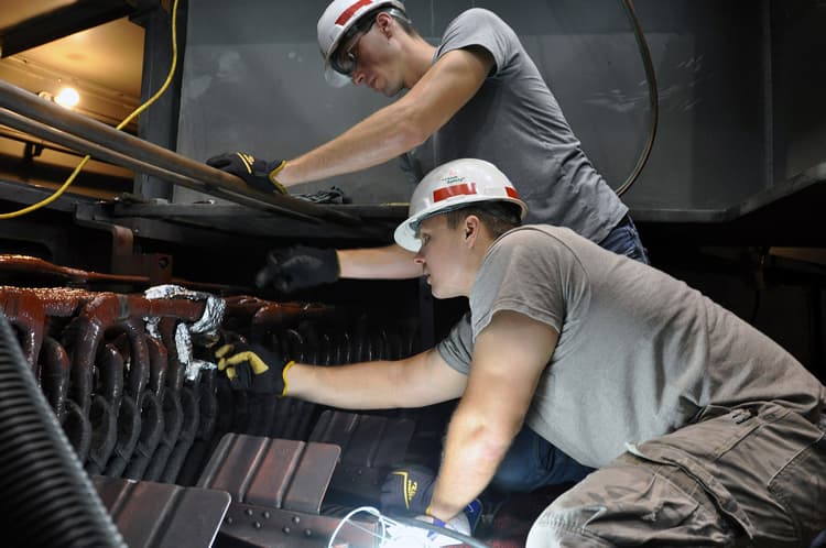 Licensed electricians working on electrical equipment with tools and meters