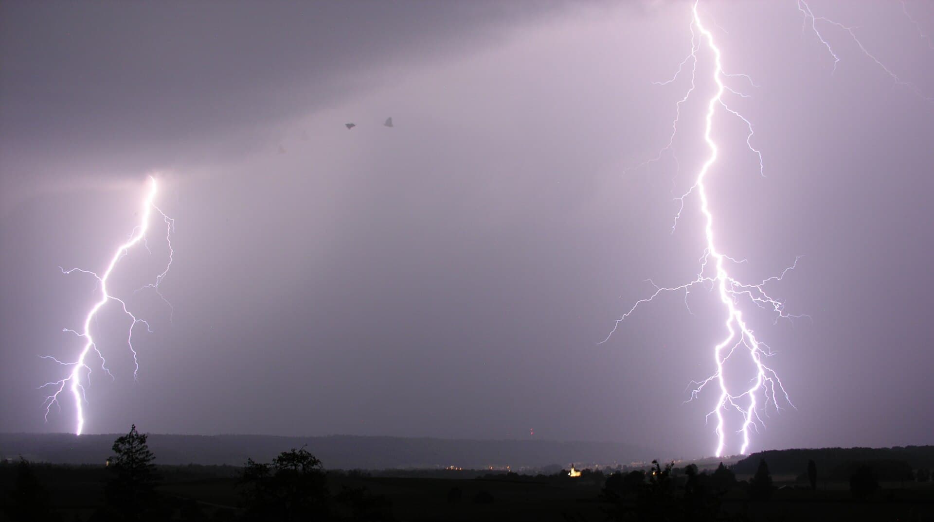 A cloud-to-ground lightning strike during a night thunderstorm